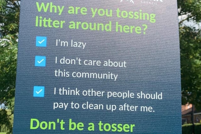 Photograph of sign in park promoting safe disposal of litter