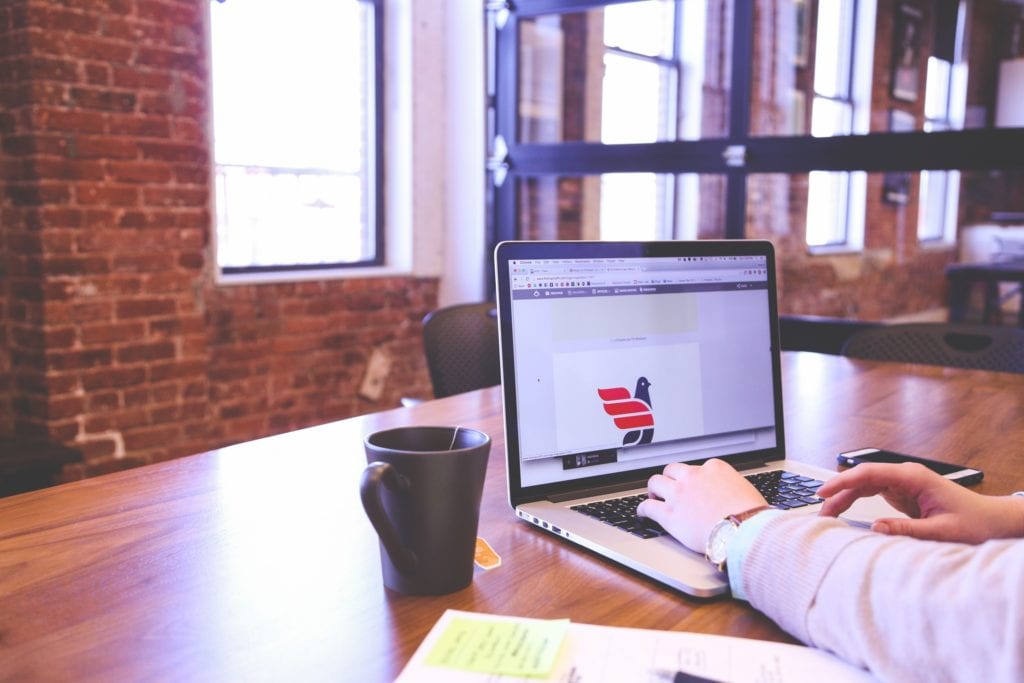 Photograph of a person working at their laptop in a modern office