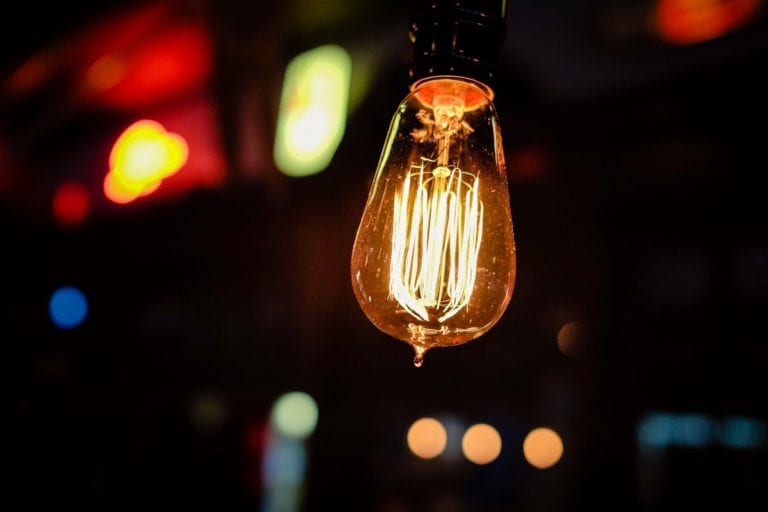 Photo of glowing filaments in lightbulb against nighttime background